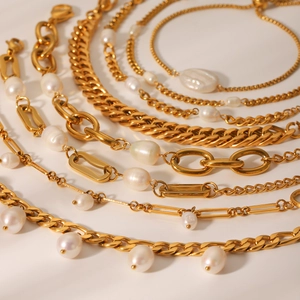 Detail of gold stainless steel Figaro chains with natural freshwater pearls