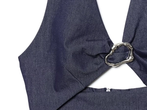Detail of blue denim dress with halter neck, cutout design and silver metal ring
