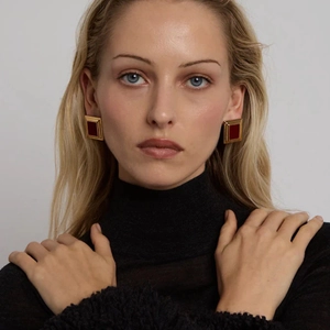 Geometric square gold-edged red stud earrings in titanium steel worn by a model