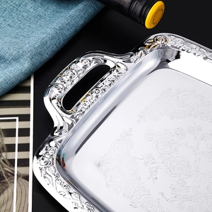 Silver rectangular stainless steel tray with embossed floral patterns and carved handles