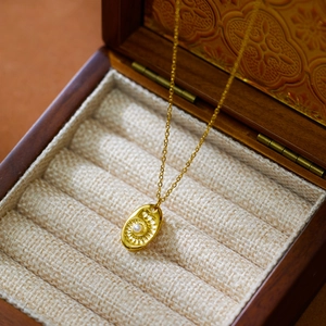 Détail du collier plaqué or 18 carats avec pendentif soleil et perle blanche