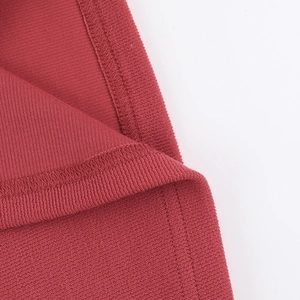 Gros plan sur un tissu en maille côtelée rouge avec des coutures de bord soignées