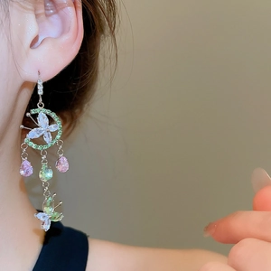 Close-up of floral glass bead fringe earrings with butterfly design and crystals