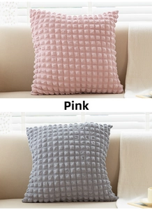Detailed close-up of soft pink and grey popcorn textured cushion covers for sofa