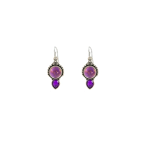 Macro shot of vintage silver earrings with teardrop purple gems and round stone detail