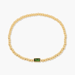 Elegant gold beaded bracelet featuring a rectangular green emerald gemstone centerpiece