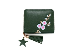 Detail of dark green small zipper wallet with floral embroidery and star tassel charm