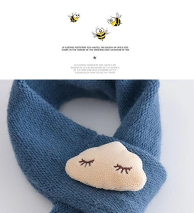 Close-up of soft blue knitted baby scarf with cute plush cloud detail and knit texture