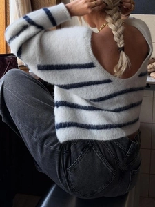 Close-up of fluffy white and blue striped knit sweater featuring a stylish back V-neck design