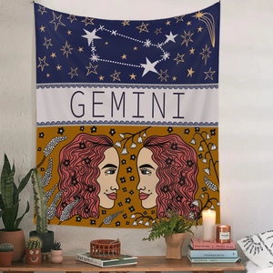 Detail of a Gemini zodiac tapestry with floral patterns and astrology symbols on a wall