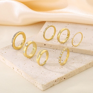 Detail of 18K gold-plated eternity rings with zircons on stone and silk background