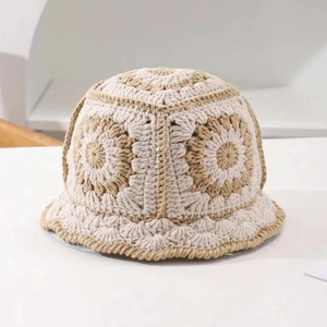 Detailed macro view of handmade crochet knit floral patterns on beige bucket hat
