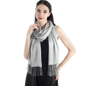 Detail of silver-grey evening shawl with elegant tassels and shimmering metallic texture