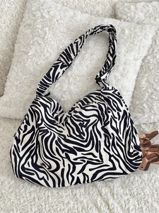 Large zebra print corduroy tote bag with wide shoulder strap on a plush white background