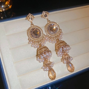 Detail of vintage bohemian Jhumka earrings with amber crystals and pearl tassels in a box