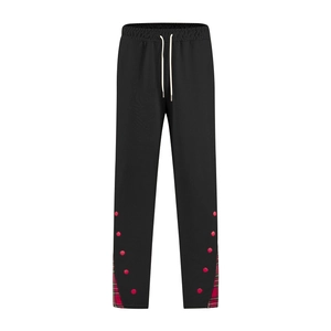 Détail du pantalon de jogging noir pour homme avec empiècement à carreaux rouges et pois