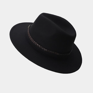Detalle de un sombrero fedora de fieltro negro con banda decorativa trenzada marrón