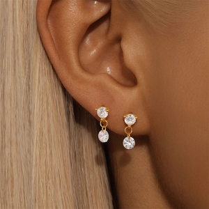 Close-up of double round zircon earrings in gold finish worn by a model