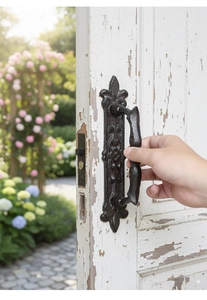 Close-up of vintage cast iron door handle with matte black finish on aged wood door