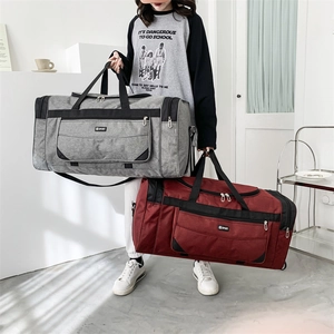 Detail of large nylon travel bags in grey and burgundy with multi-pocket storage and straps