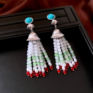 Macro shot of silver tassel earrings with gradient beads and turquoise inlays