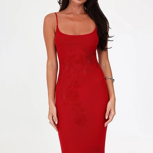 Detail of red slim fit dress showing elegant floral rhinestone embroidery and sequins