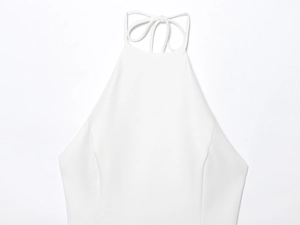 Close-up of white halter neck straps and smooth knit fabric detail on mini dress