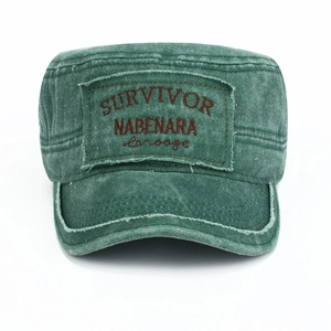 Detailed close-up of vintage washed green flat top cadet cap with embroidered patch