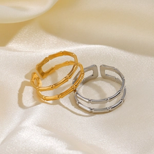 Bagues articulées bambou bicolores or et argent sur un fond élégant en soie