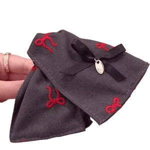 Dark gray fabric hair claw clip with red embroidered bow and metal pendant accessory