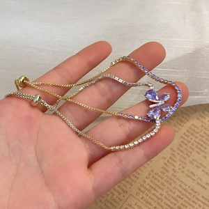 Détail du bracelet doré ajustable avec papillon en zircon violet et fermoir coulissant