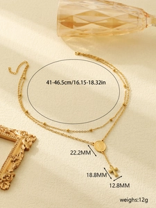 Detail view of double-layer gold necklace featuring Virgin Mary medal and cross pendant