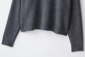Détail de la maille en laine gris foncé montrant la texture premium et la finition