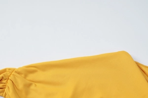 Detail shot of yellow fabric texture with side pleated design and hollow-out stitching