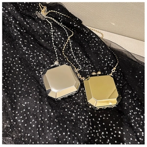Detail of octagonal mirror metal evening clutch bag with gold and silver bead chain strap