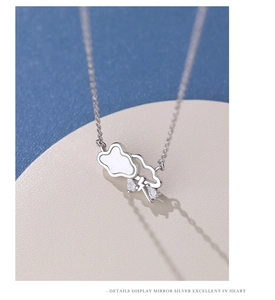 Macro detail of silver cloud necklace with white shell inlay and zircon teardrop charms