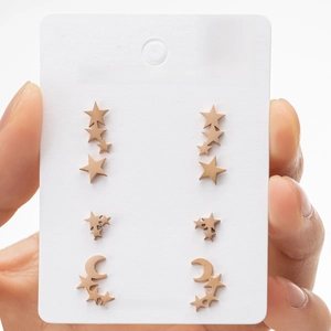 Macro shot of rose gold stainless steel star and moon stud earrings on display card