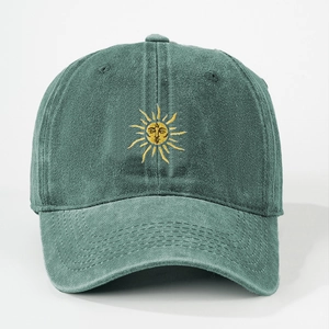 Close-up of embroidered sun face logo on vintage washed dark green cotton baseball cap