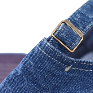 Close-up of distressed denim baseball cap with vintage brass adjustable buckle and stitching