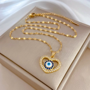 Detailed close-up of golden heart evil eye pendant necklace with sparkling zirconia