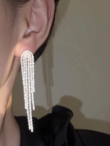 Close-up of sparkling silver tassel earrings featuring a cascading waterfall fringe design