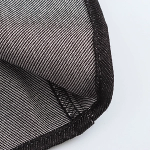 Detailansicht eines grauen Jeanskleids mit Twill-Struktur und Overlock-Nähten im Detail