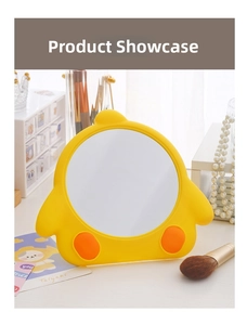 Detail of the yellow cartoon chicken makeup mirror on a white vanity with accessories