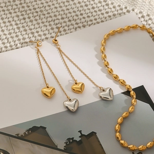 Two-tone 18k gold and silver heart tassel earrings with a matching gold beaded chain