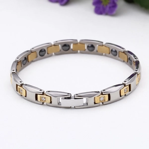 Detail of two-tone titanium steel bracelet with rhinestones and magnetic therapy beads
