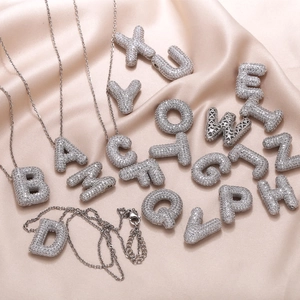 3D bubble letter necklaces with cubic zirconia pavé stones on champagne satin fabric