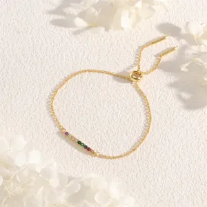 Detail of adjustable gold bracelet featuring rainbow cubic zirconia and slider clasp
