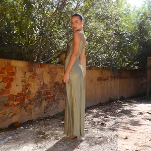 Detailed view of glossy olive green satin dress fabric and elegant side slit design