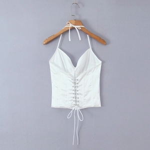 Détail du haut dos nu en satin blanc avec œillets argentés et laçage frontal ajustable
