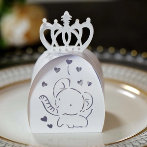 Macro shot of white crown-shaped candy box with intricate laser-cut elephant pattern